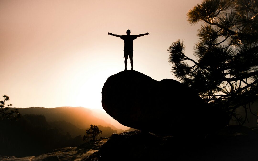 silhouette of person on rock
